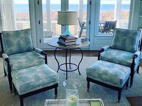 Two blue chairs split by a round end table